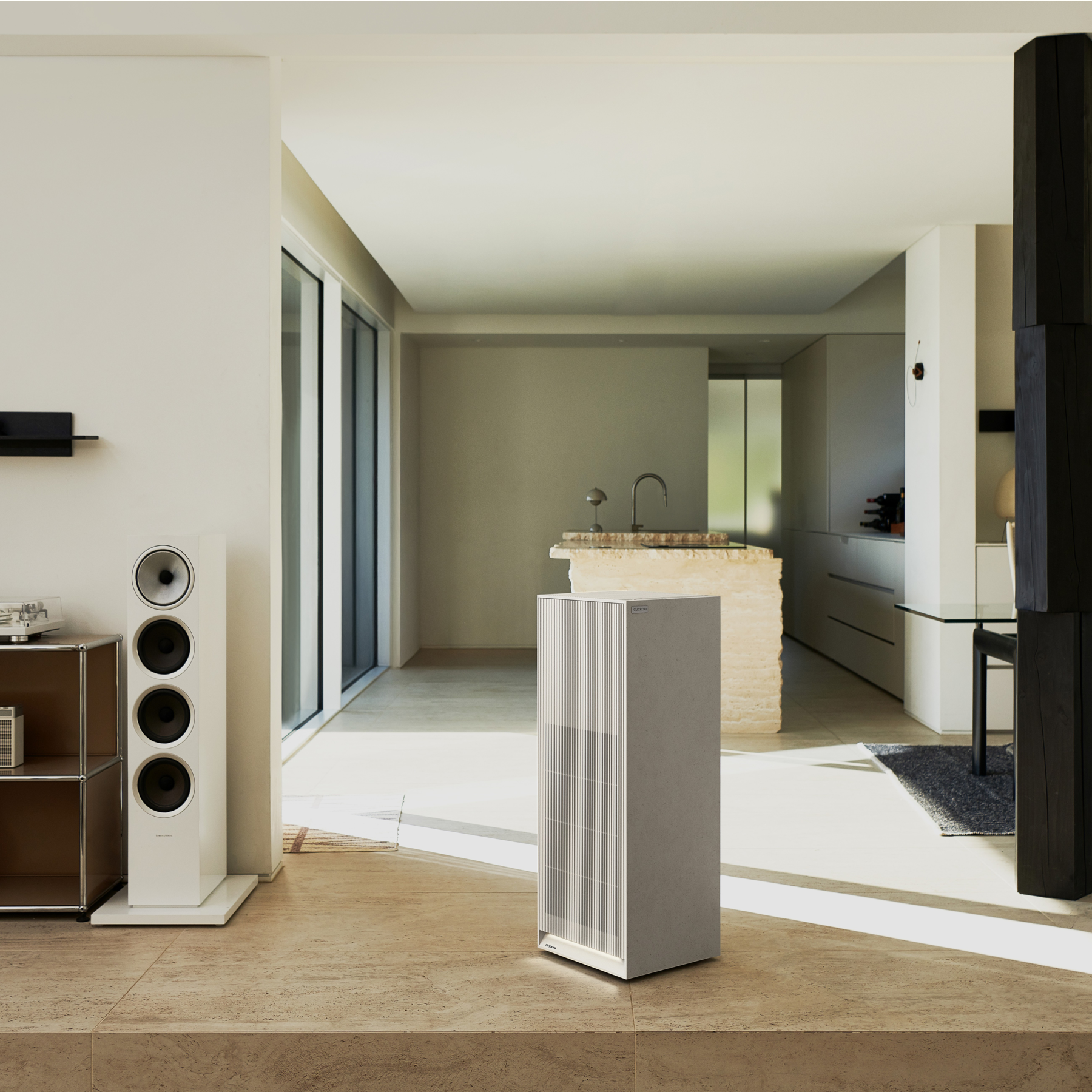 Earth Warm White Inspure Heritage air purifier placed in a modern living room alongside a white floor-standing speaker. (CAC-AH2810FNW)