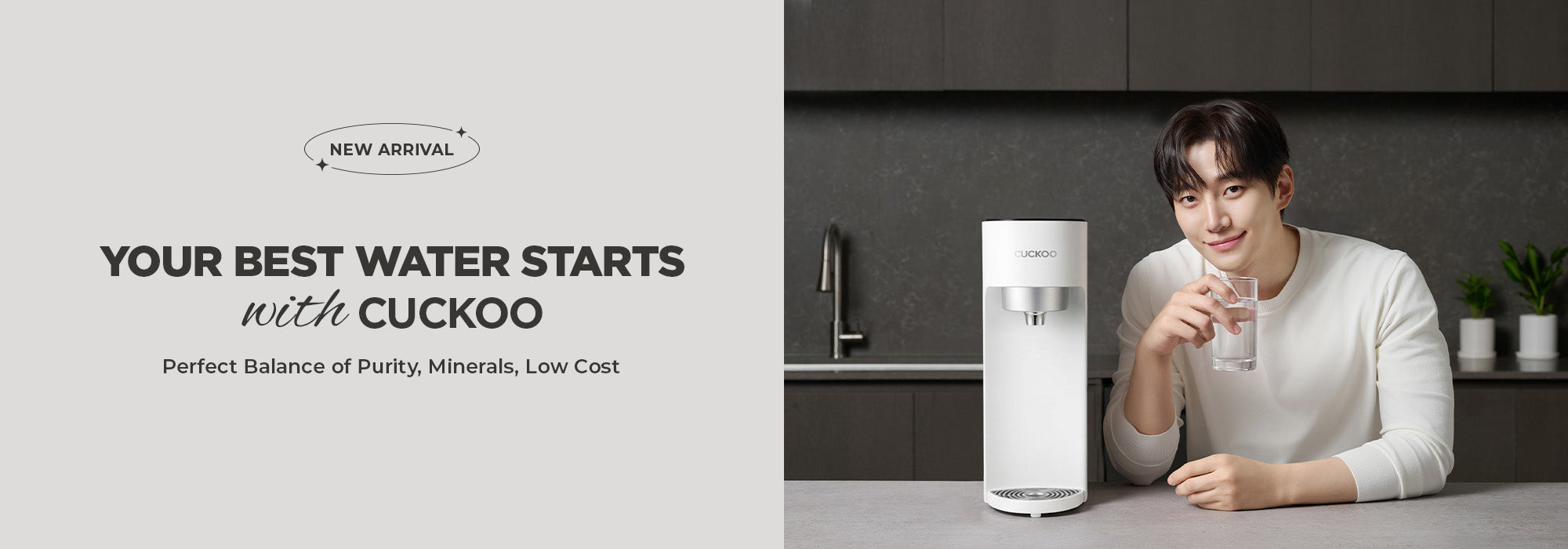 A man in a white sweater sits at a kitchen counter next to a white Cuckoo water purifier, holding a glass of water. The left side of the image features a light gray panel with promotional text for the Cuckoo water purifier.